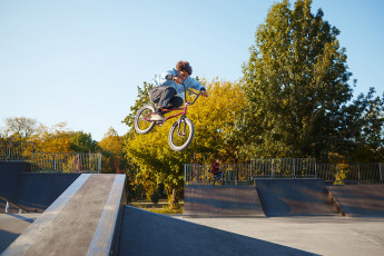 Bmx,Biker,Rides,By,Railing,In,Skatepark
